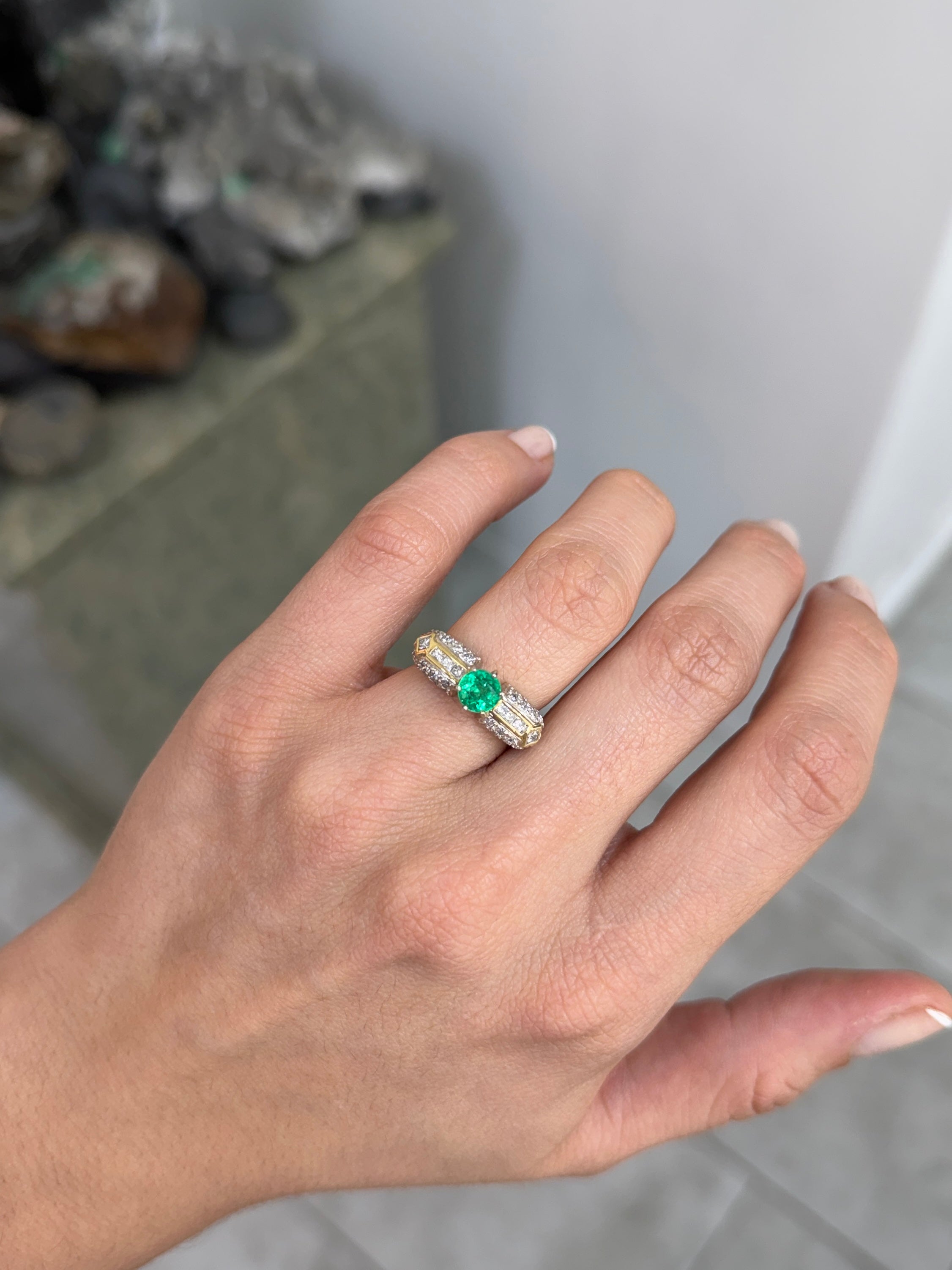 18K gold engagement ring featuring a 1.85 tcw round cut Colombian emerald with diamond accents