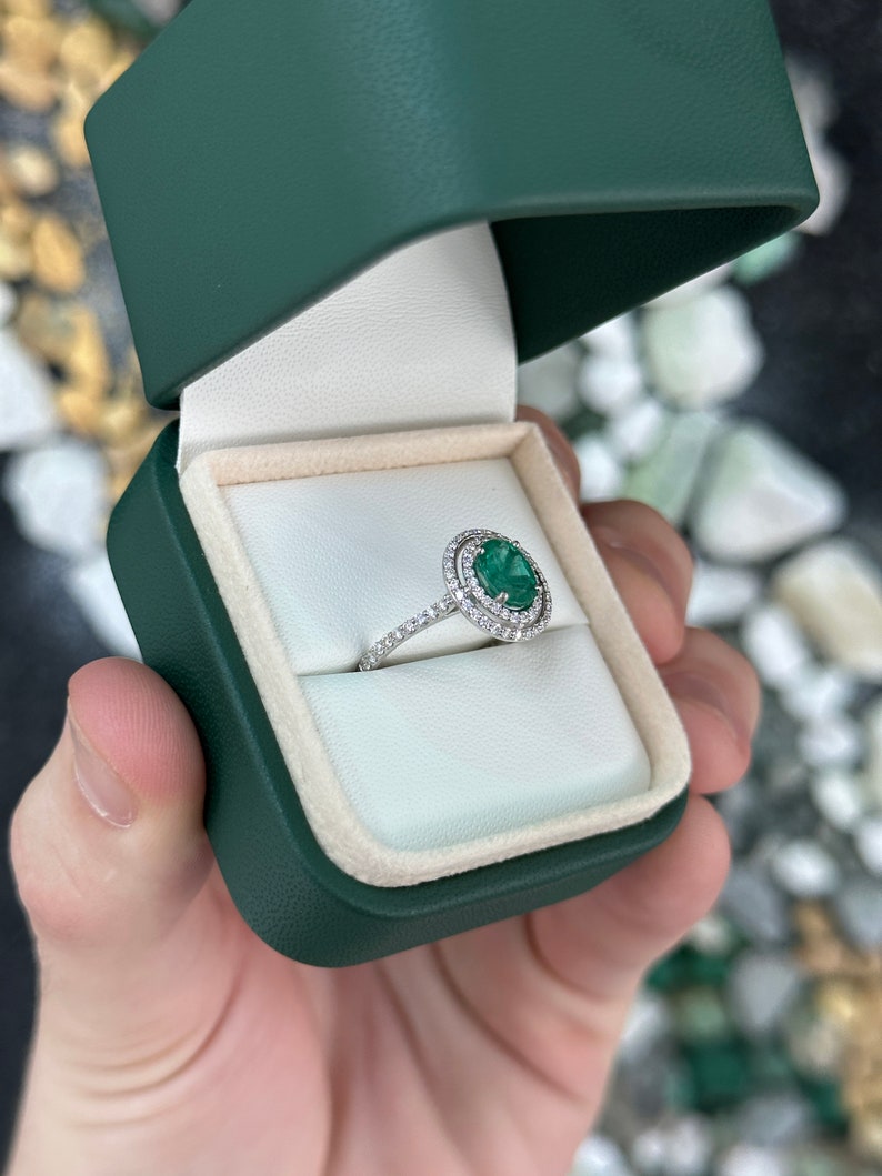 Colombian Emerald engagement ring with 8x6 oval-cut green emerald and double diamond halo in 14K white gold.