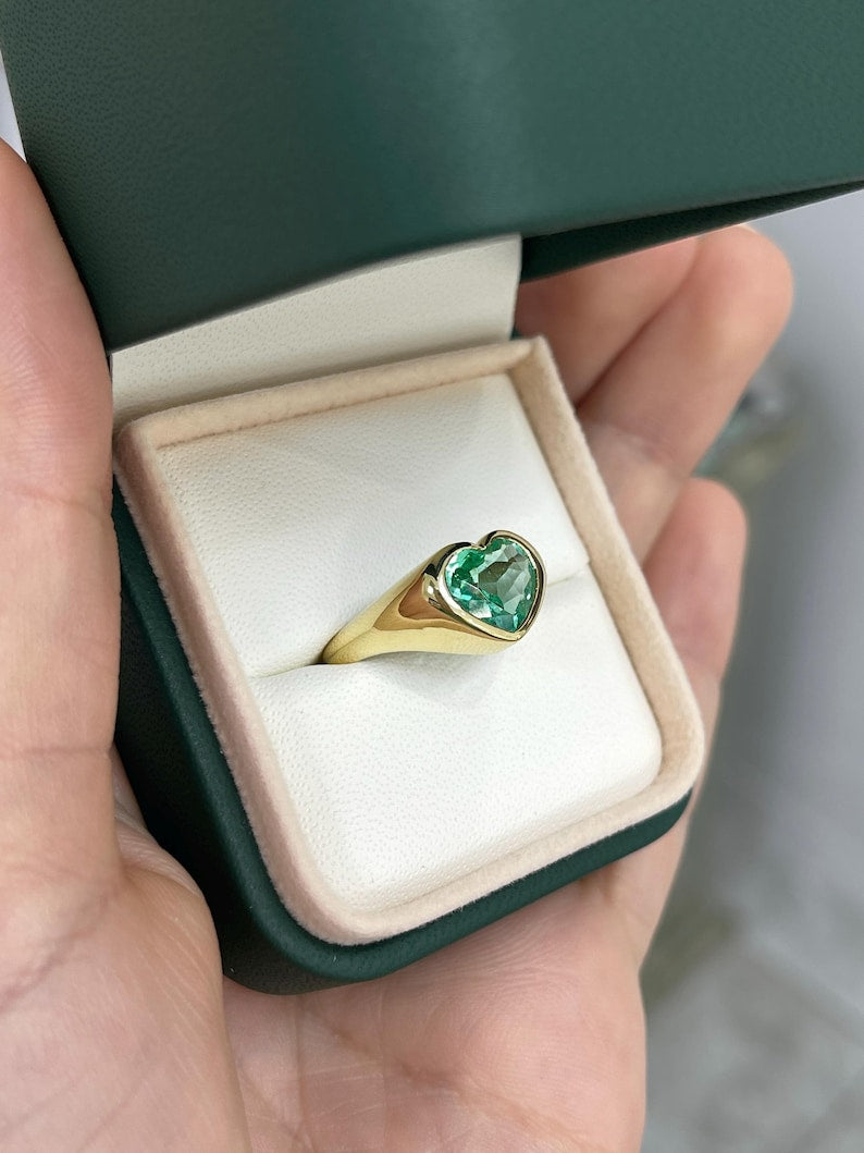 Unisex engagement ring with 2.19ct Colombian emerald bezel-set heart-cut diamond in 18K gold, designed for Nabil and Tara.