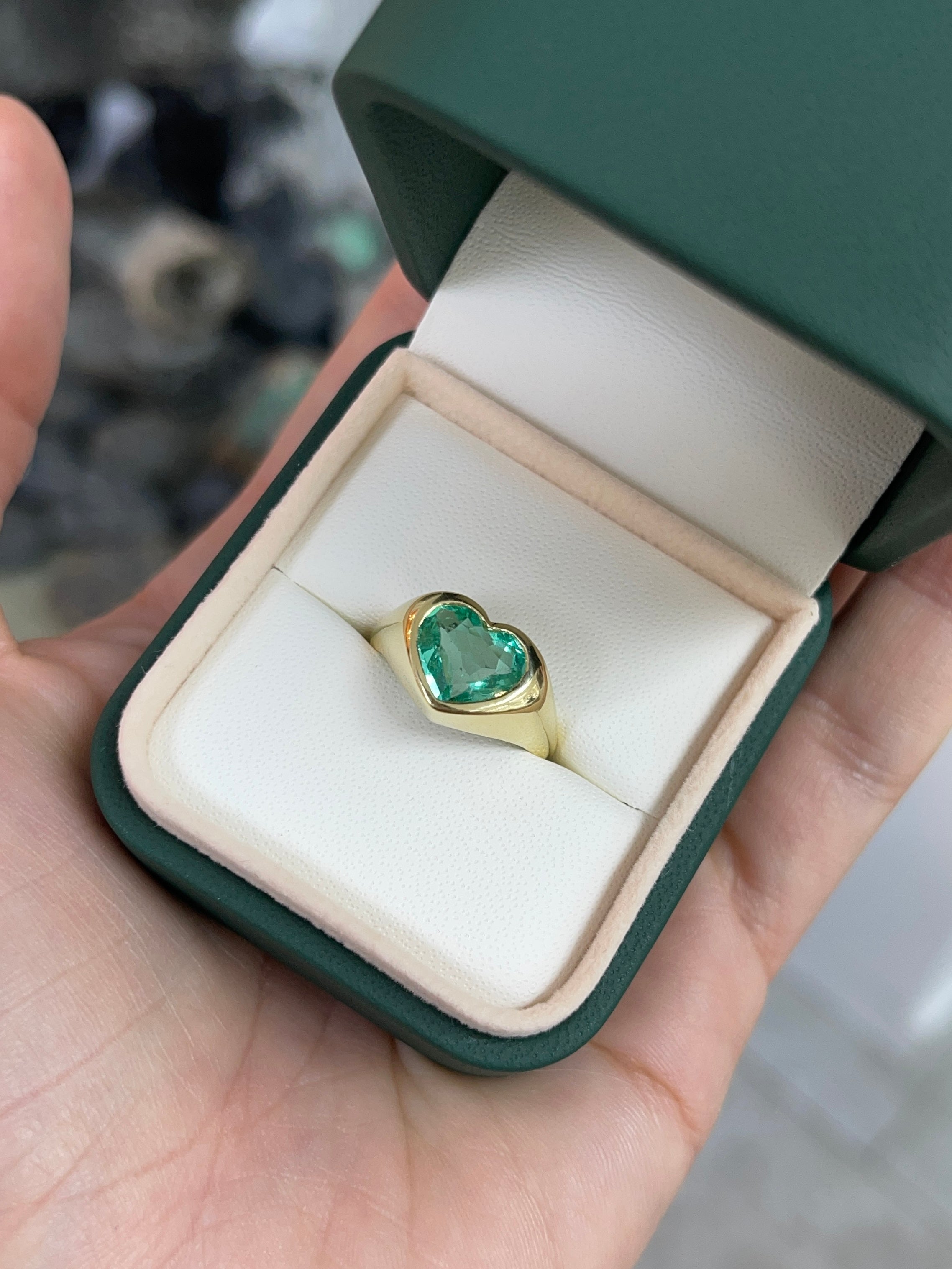 Unisex 18K gold engagement ring with heart-cut Colombian emerald bezel setting, designed for Nabil and Tara.