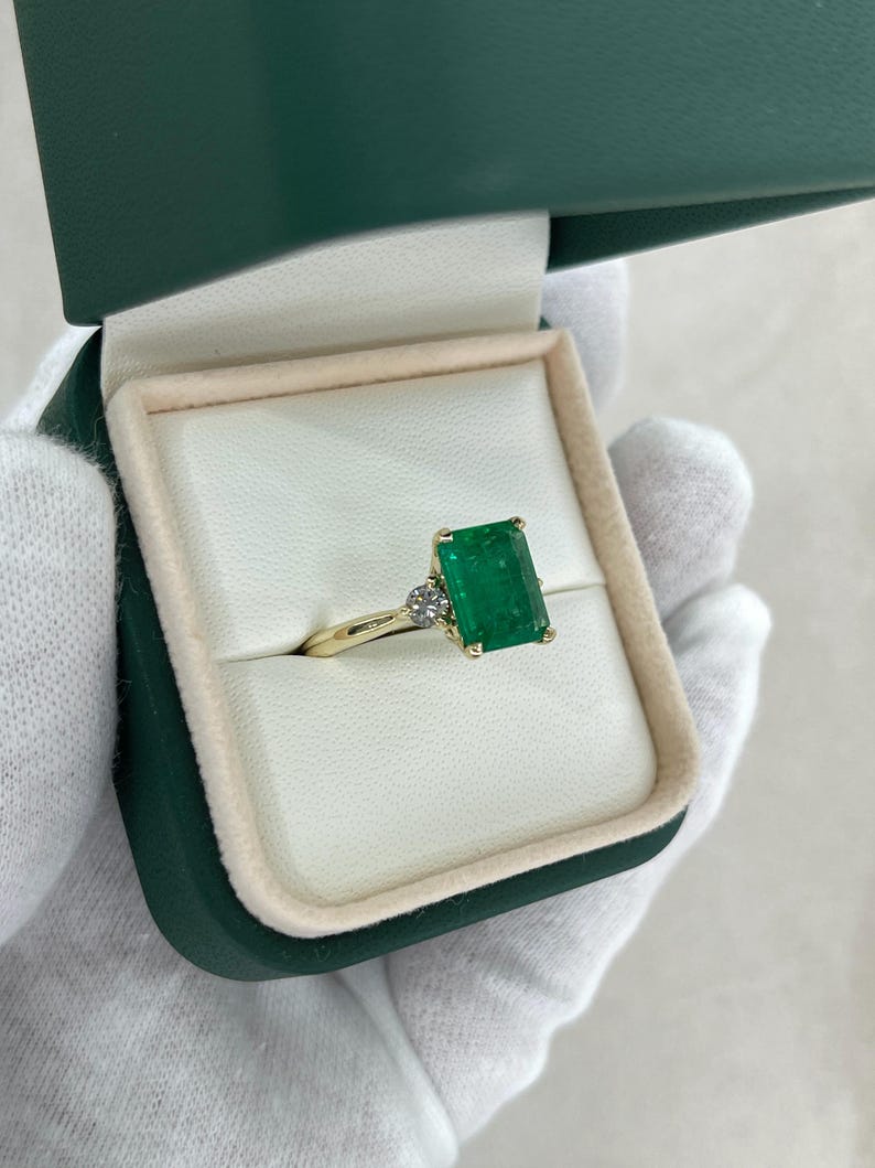 14K green emerald cut and round diamond three-stone engagement ring with 4.27 carats from Colombian Emerald.