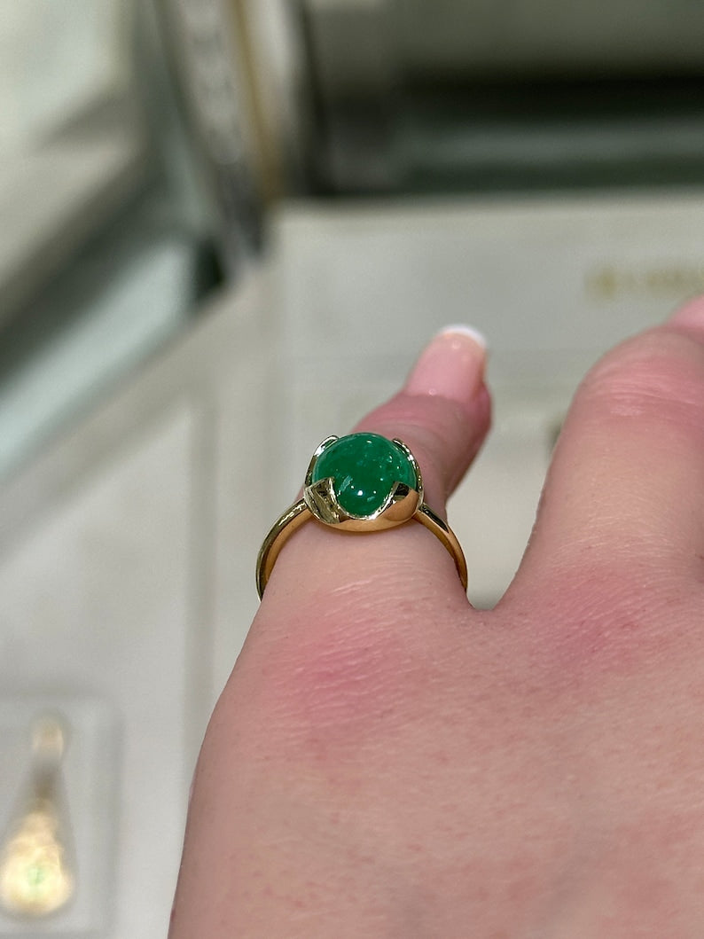 14K gold engagement ring featuring a 4.29-carat dark green oval cabochon emerald in a Colombian Emerald solitaire setting.