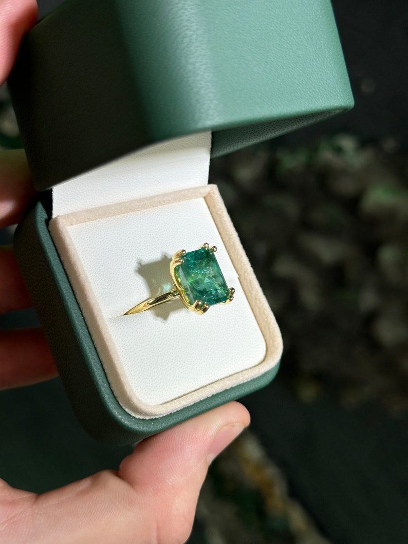 14K emerald cut solitaire engagement ring with 7.35ct Colombian Emerald and chunky claw prongs.