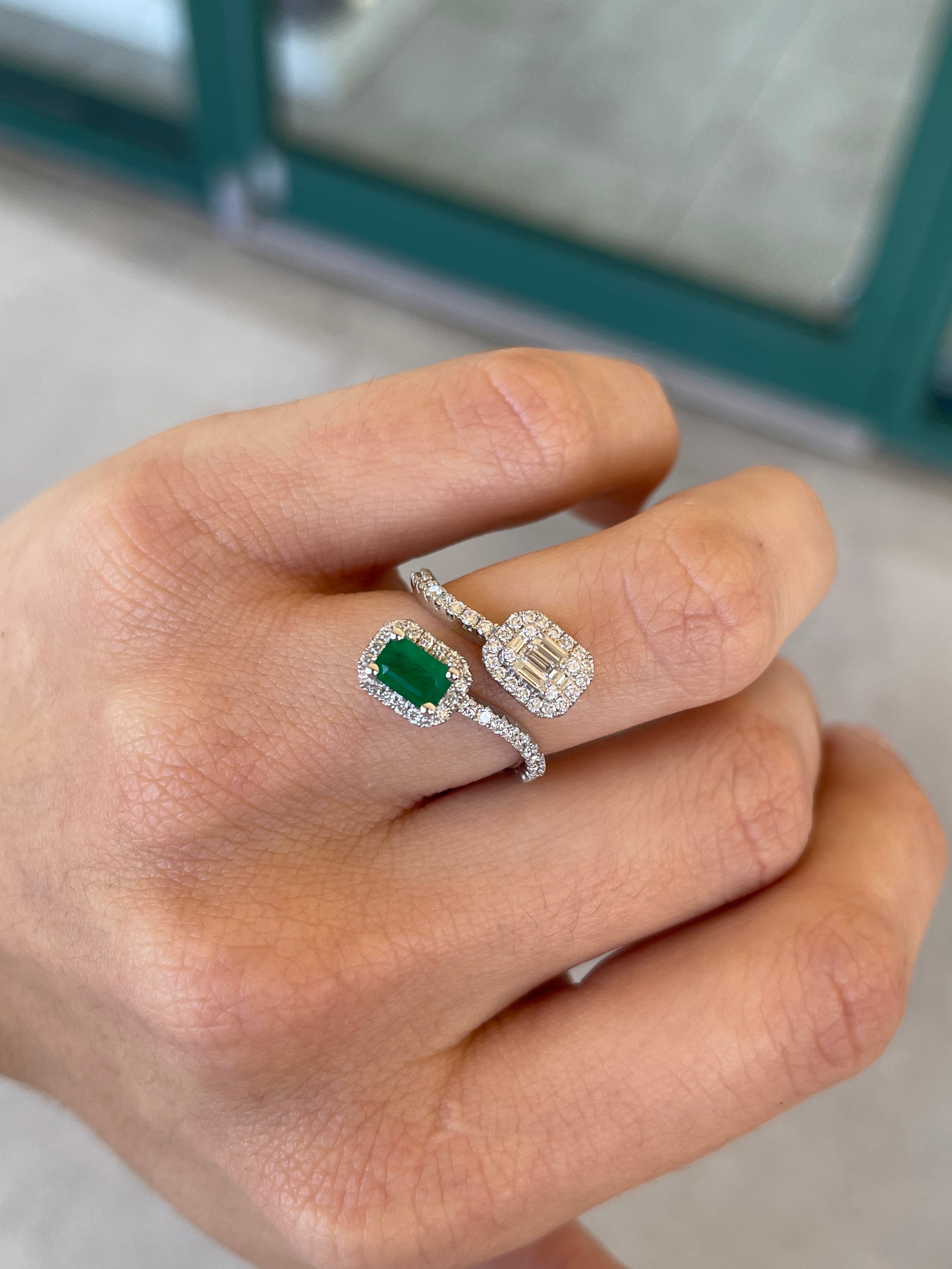 Ladies emerald ring featuring 1.51 tcw dark vivid green baguette and round cut emeralds in 14K white gold bypass shank design.