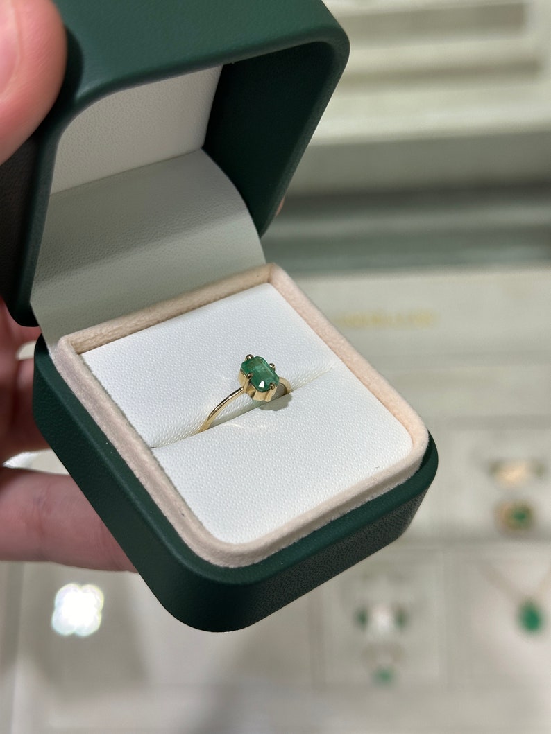 14K Colombian emerald solitaire ring with a 0.70ct round emerald in a four-prong North to South setting for women.