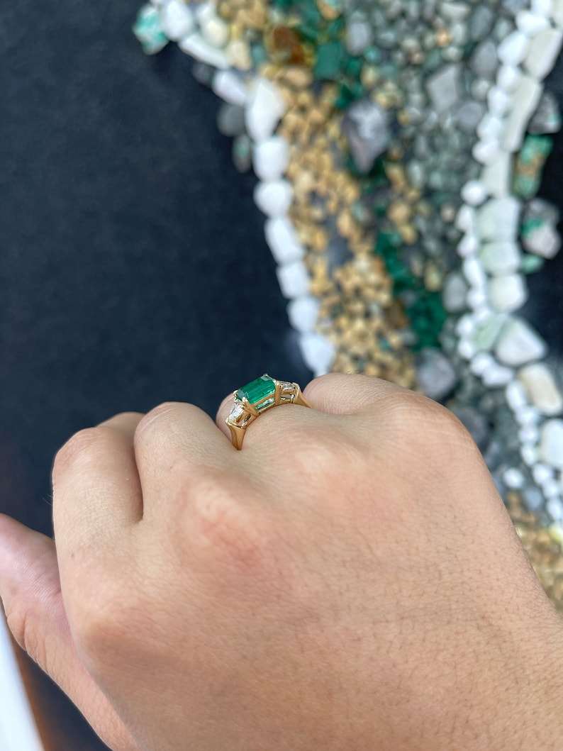 Colombian Emerald ladies ring with 2.58tcw 14K gold, east-west emeralds, and trillion-cut diamonds in a three-stone design.