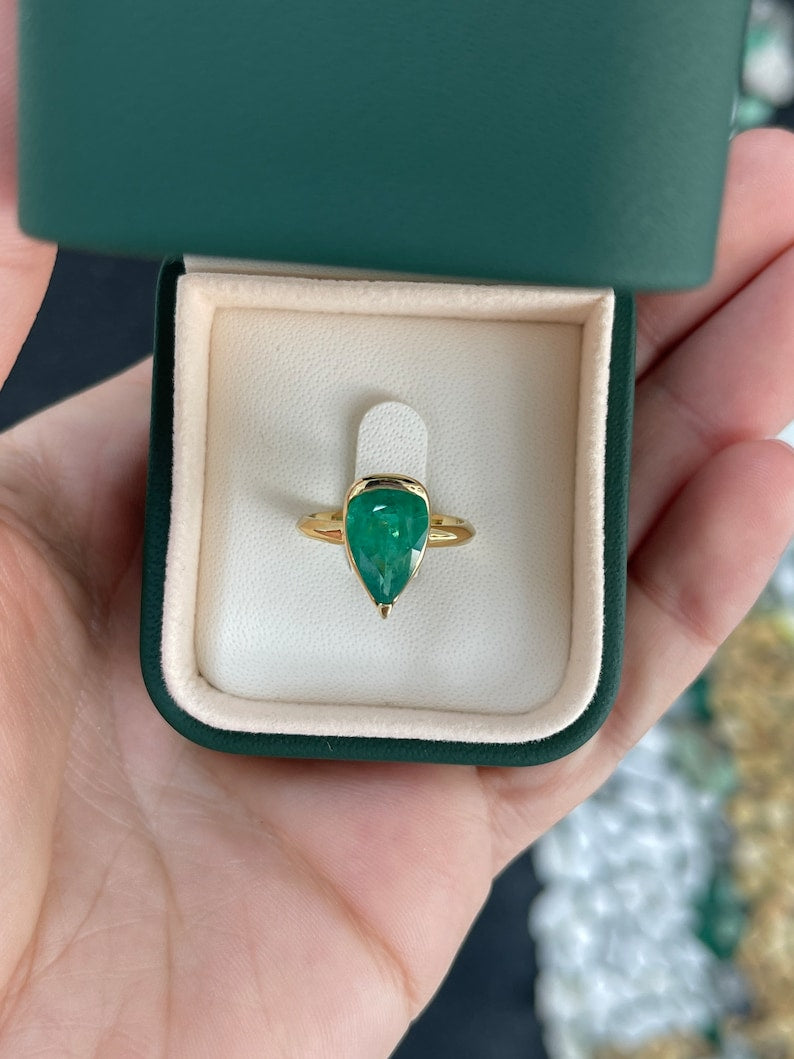 Ladies emerald ring featuring a 3.10ct dark green pear-shaped Colombian emerald solitaire set in 18K gold.
