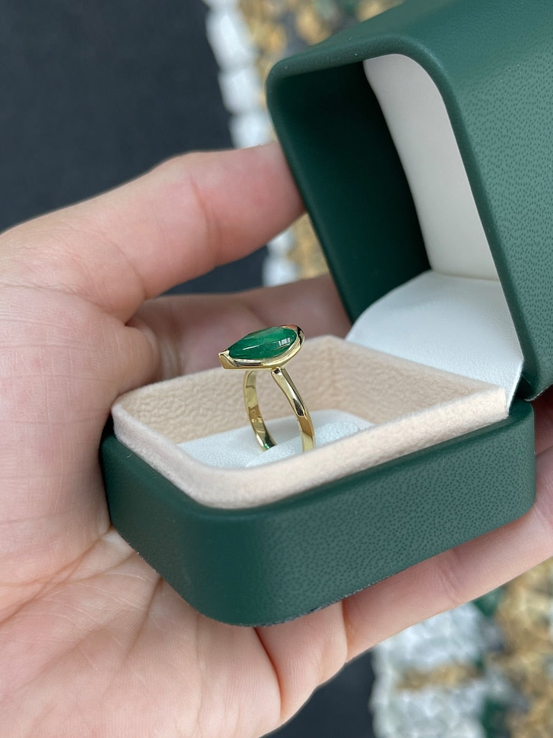 Ladies emerald ring featuring a 3.10ct dark green pear-cut Colombian emerald in 18K gold solitaire setting.
