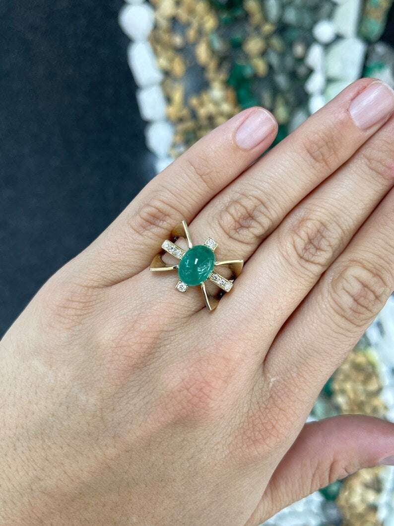 Ladies emerald ring featuring a 5.12tcw natural green cabochon emerald with diamond accents in a gold star-styled setting.