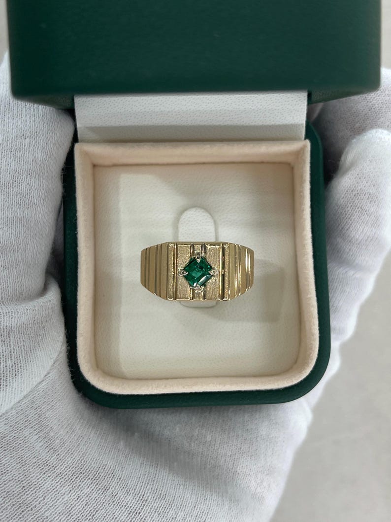 Mens pinky ring featuring a 0.60ct emerald cut rich green Colombian emerald solitaire set in 14K gold.