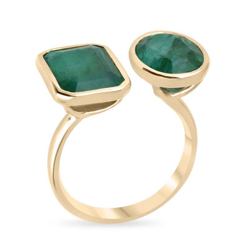 Men's 18K gold Toi Et Moi ring featuring two deep green emerald and oval cut emerald stones, Colombian Emerald brand.