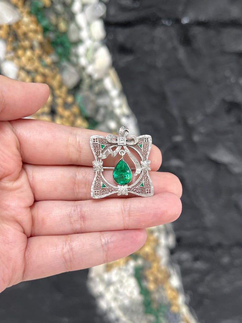 Vintage pendant and brooch featuring 2.65tcw Colombian emerald pear cut with diamonds in a 14K setting.