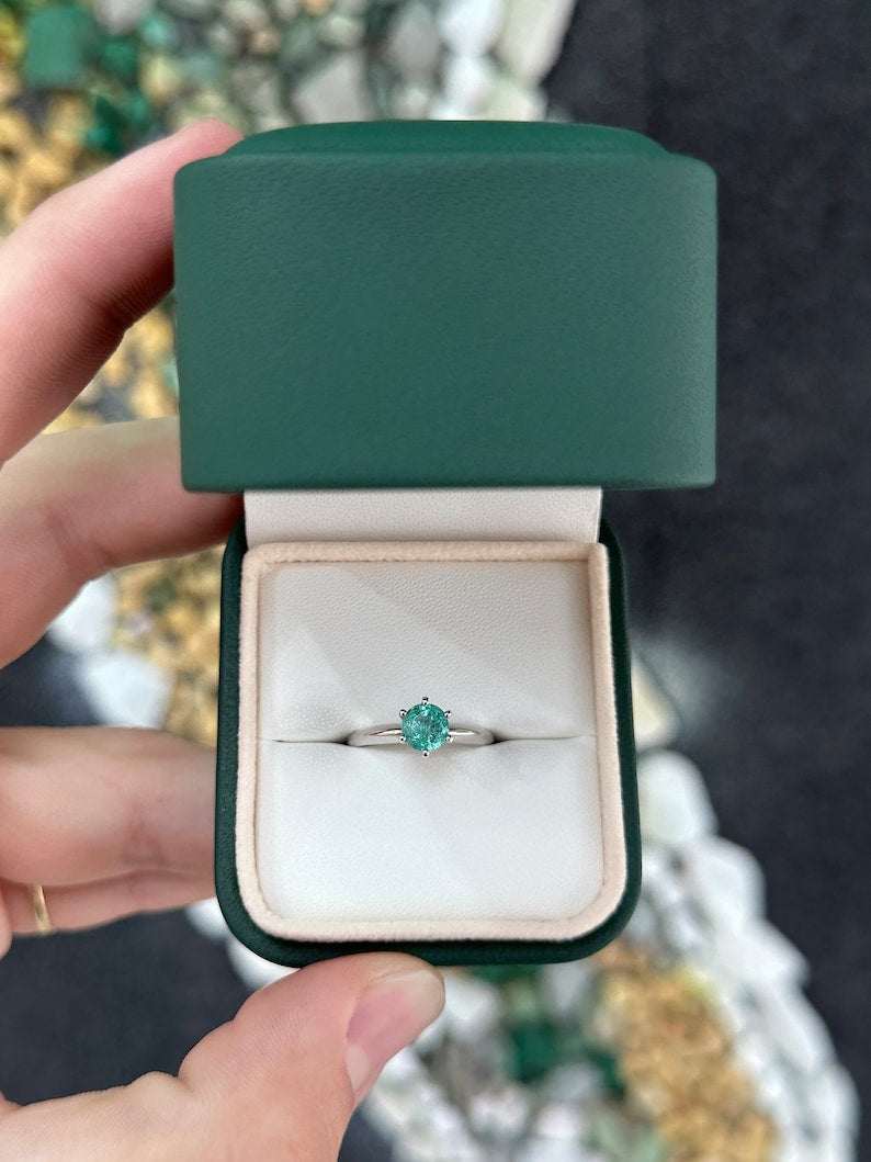 Colombian Emerald 0.80ct round cut ocean blue engagement ring with six prongs in 14K gold, showcasing the vibrant gemstone.