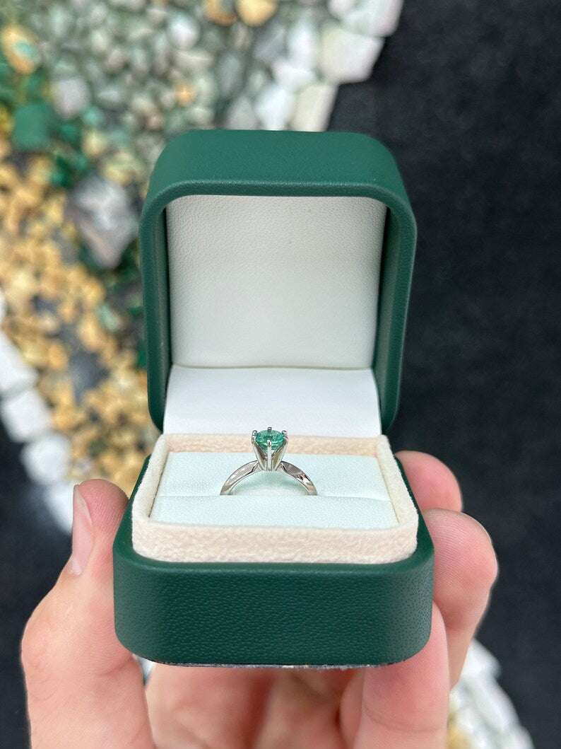 Colombian Emerald 0.80ct round cut ocean blue engagement ring with six prongs in 14K gold.