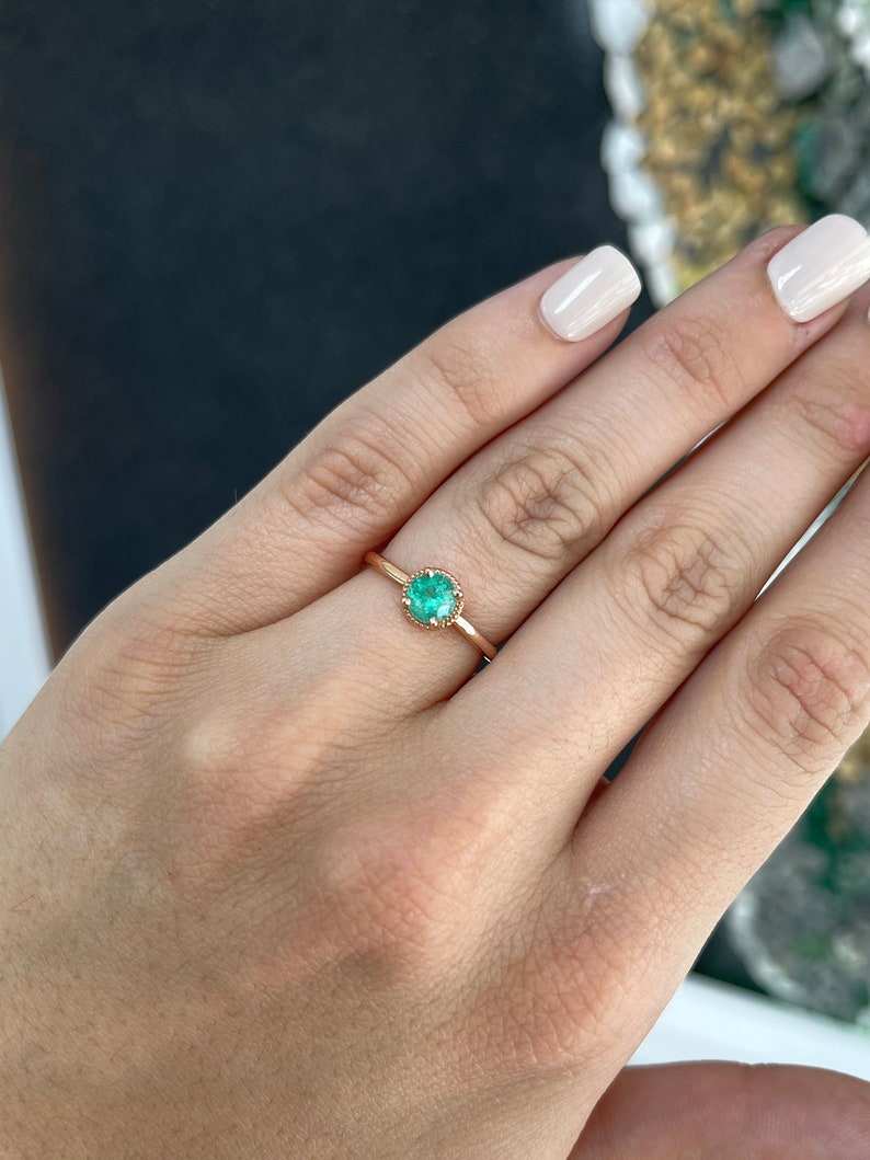 14K rose gold engagement ring with a 0.90ct round cut emerald solitaire from Colombian Emerald, designed for right hand wear.