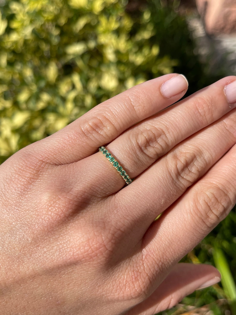 Medium dark green round cut emerald half eternity ring in 14K gold from Colombian Emerald, showcasing a continuous band of emeralds.