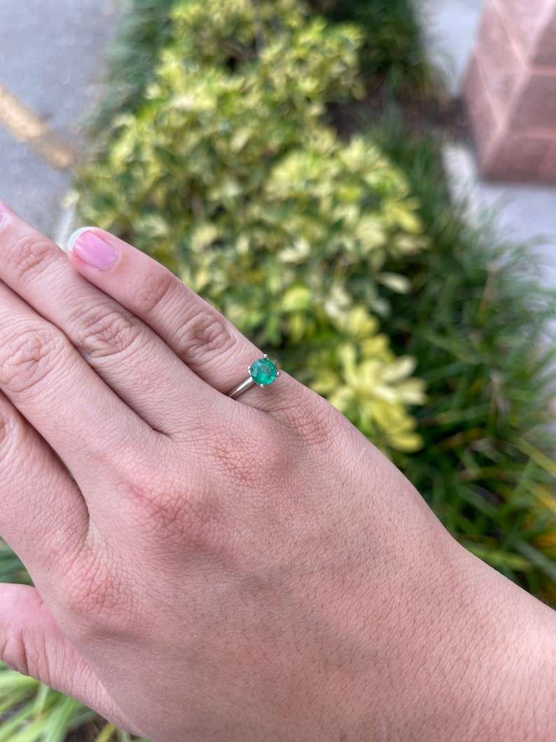 14K white gold engagement ring with 0.93ct medium dark green emerald round cut in a 4-prong solitaire setting