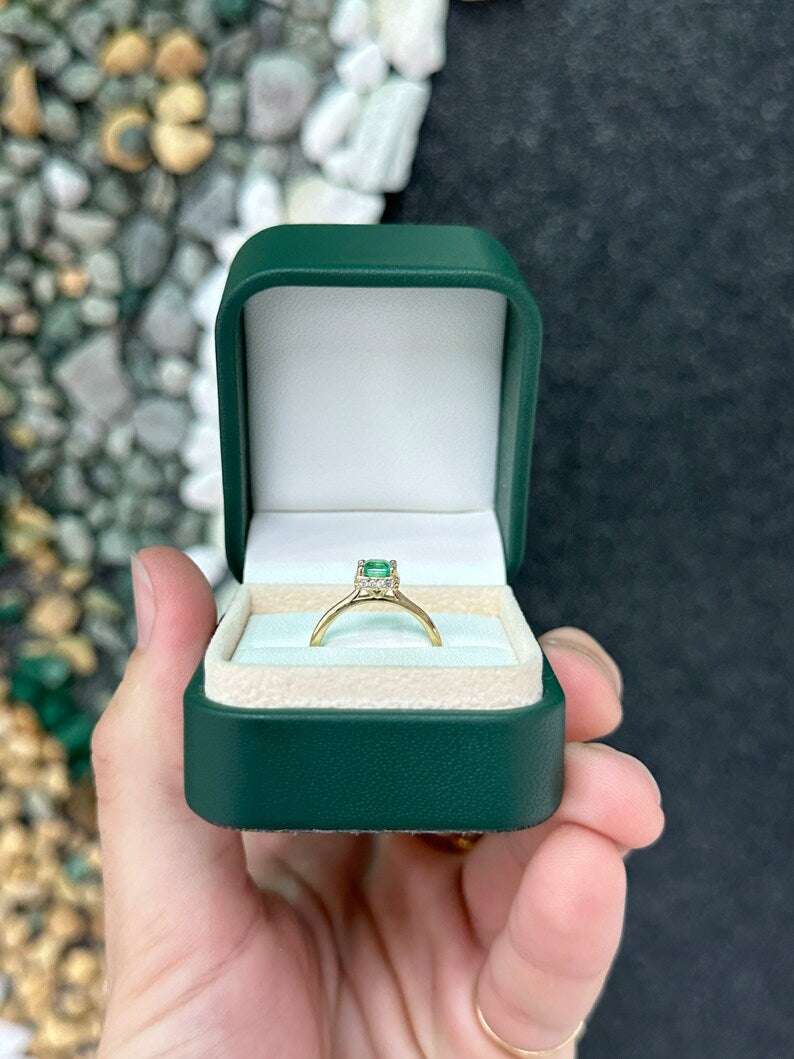 Natural Asscher emerald and hidden diamond halo solitaire ring in 14K gold, showcasing a stunning green emerald with sparkling accents.