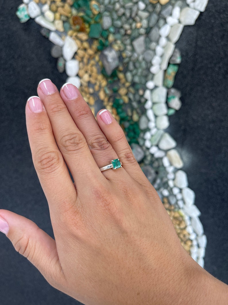 Sterling silver 925 Asscher cut emerald ring featuring a 1.30ct bluish green emerald with a 4-prong setting.