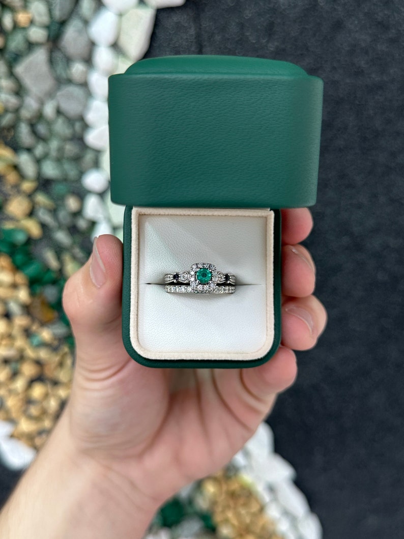 Intricate 14K gold engagement ring with natural emerald, sapphire, and diamond accents, featuring detailed craftsmanship.