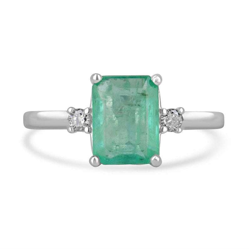 Sterling silver three-stone ring with three green emerald-cut diamonds and round diamond accents, Colombian Emerald brand.
