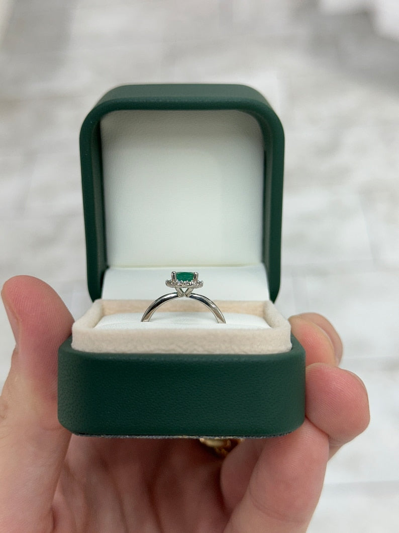 14K gold emerald and diamond accent ring featuring a 1.30tcw oval cut natural emerald and petite dark green diamonds.