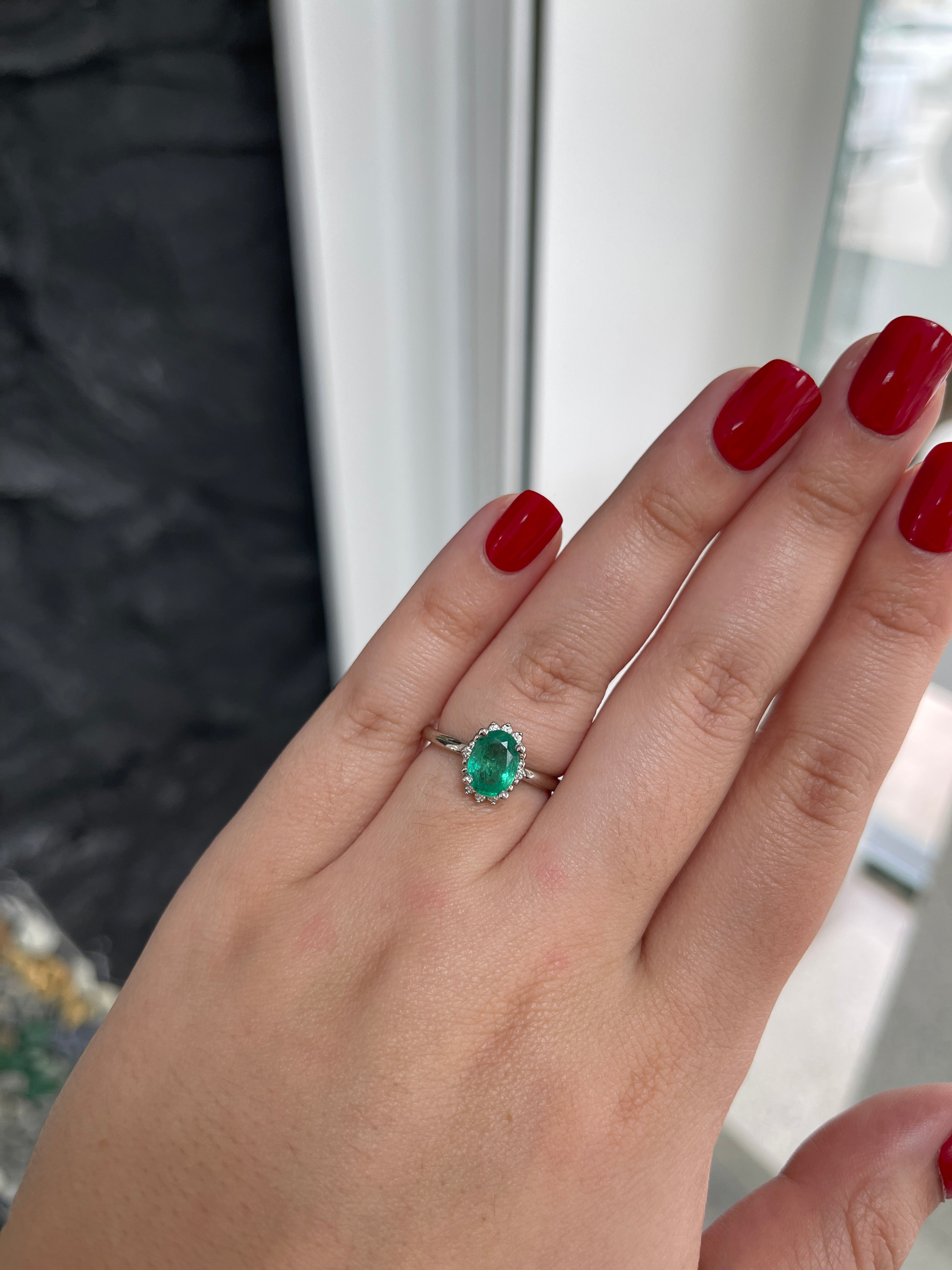 14K gold ring with oval-cut emerald and dark green diamond accents, featuring a natural Colombian emerald in a stylish design.