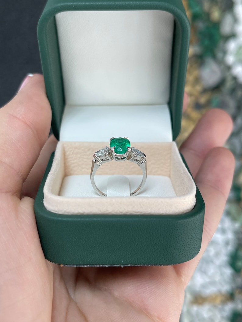Colombian Emerald three-stone engagement ring with vivid dark green emeralds and diamond accents in a fine quality ring design.