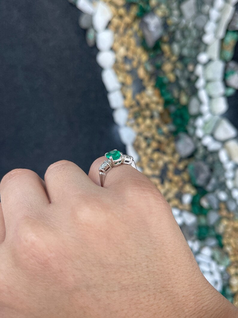 Colombian Emerald three-stone engagement ring with dark green emeralds and diamond accents in a fine quality ring setting.