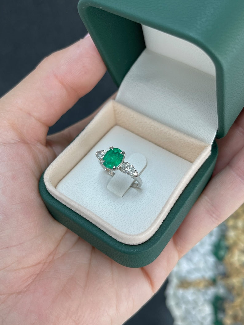 Three-stone engagement ring featuring a vivid dark green emerald with diamond accents, crafted by Colombian Emerald.