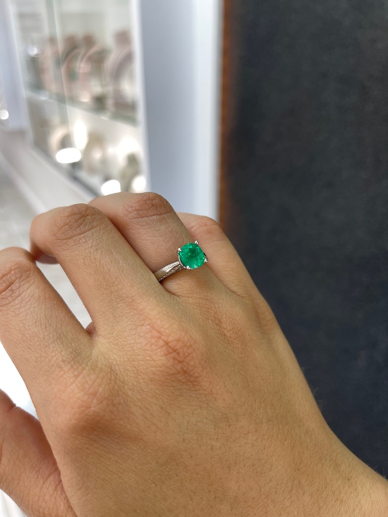 18K white gold engagement ring with AAA cushion cut emerald and diamond accents, featuring a 2.44 carat total weight.