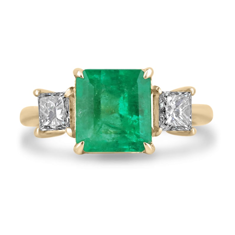 Colombian Emerald and princess cut diamond 3-stone ring in 14K gold, featuring vibrant green emeralds and sparkling diamonds.