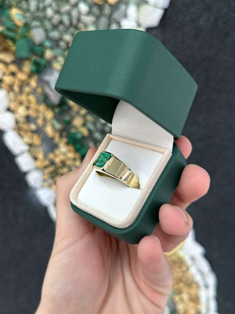 Men's 14K gold ring with a 2.65ct lush dark green emerald cut Colombian emerald, set north to south.