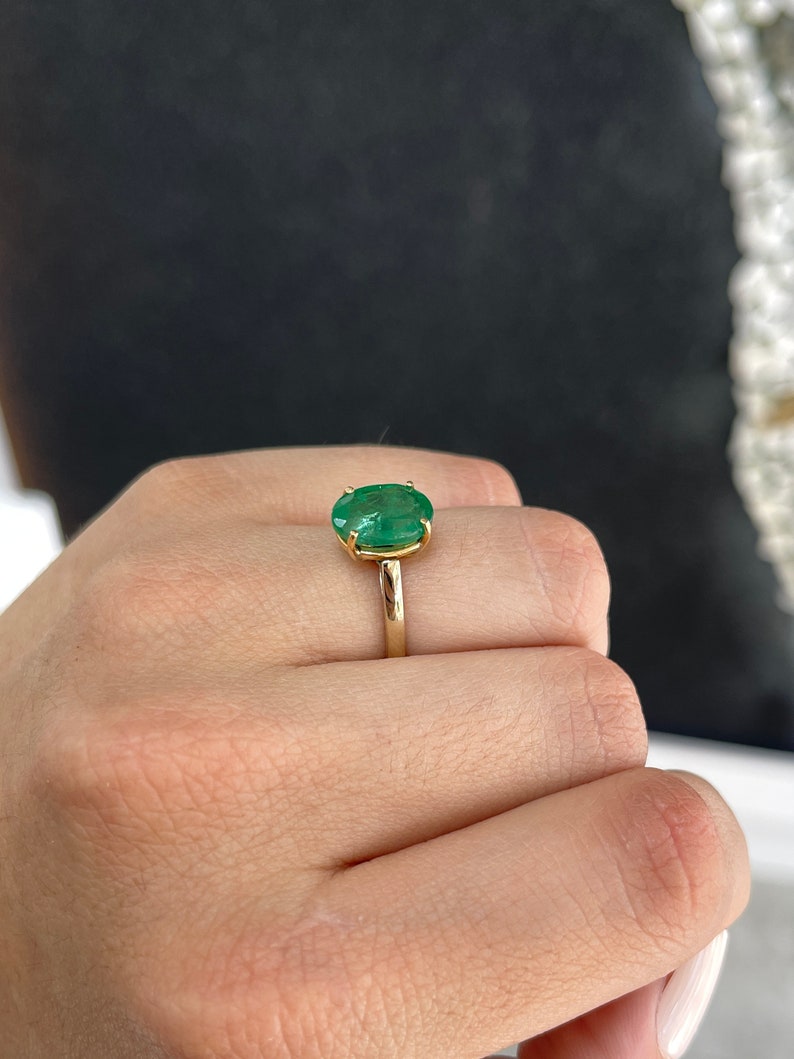 14K gold oval cut forest green emerald solitaire ring with four prongs, designed for right hand wear by Colombian Emerald.