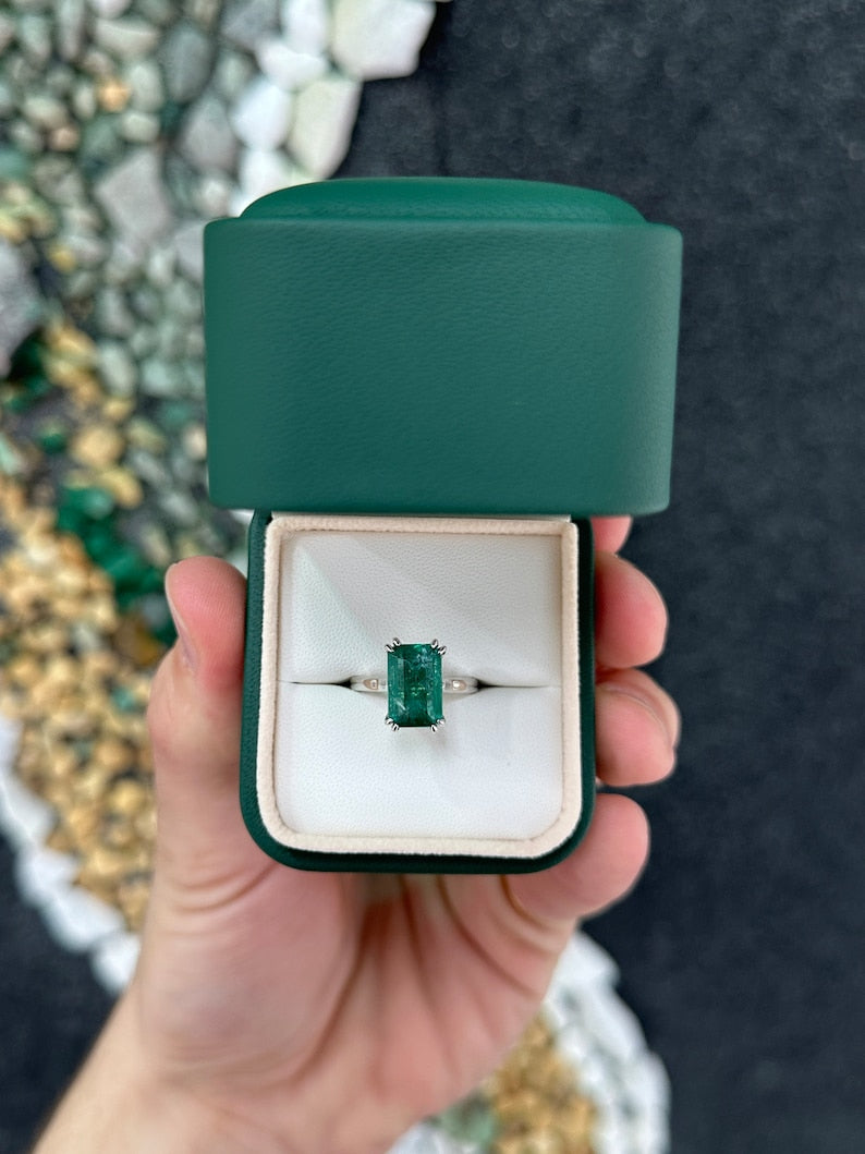 14K gold emerald cut dark green emerald solitaire ring with double claw prongs, Colombian Emerald brand, showcasing elegant jewelry design.
