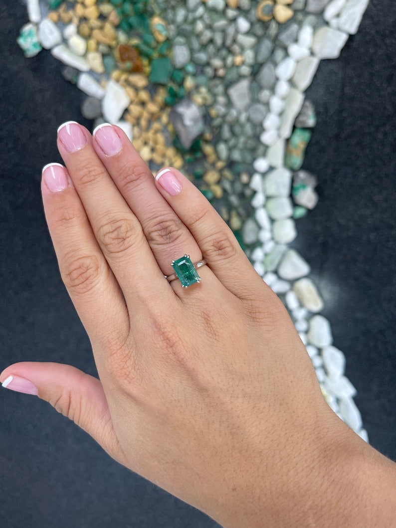 14K gold emerald cut dark green emerald solitaire ring with double claw prongs, Colombian Emerald brand, showcasing the elegant design.