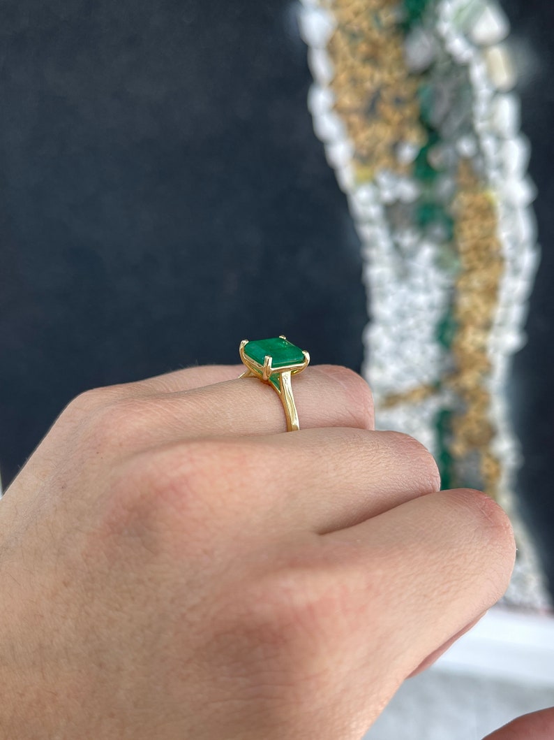 14K gold emerald solitaire ring with a 3.95ct rich green Colombian emerald and four-prong setting for right hand wear.