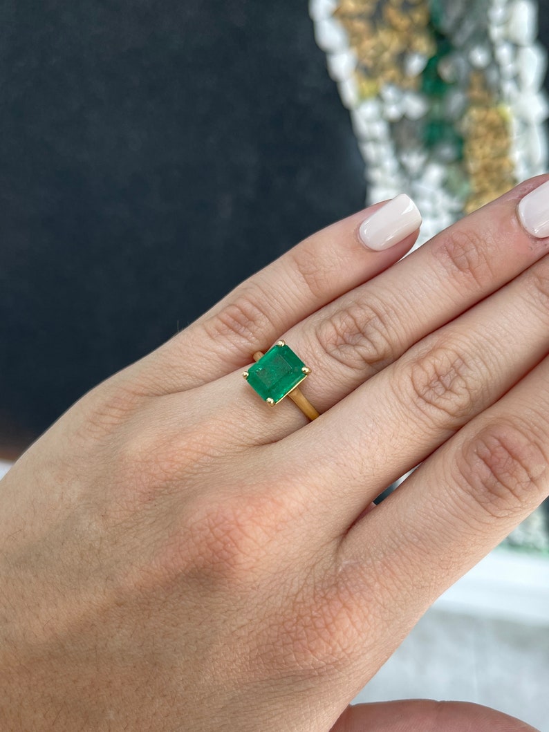 18K gold emerald solitaire engagement ring featuring a 3.95ct rich green Colombian emerald with four prongs on a sleek ring band