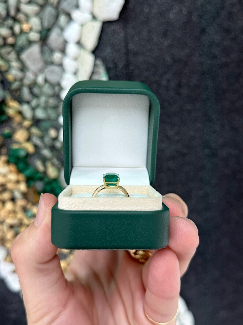 14K gold engagement ring featuring a 4.08ct rich green emerald cut solitaire with four prongs, Colombian Emerald brand.