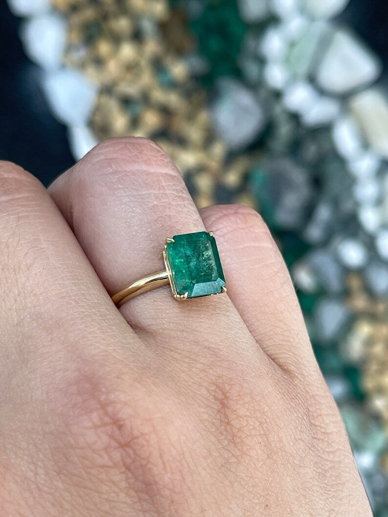 14K gold Colombian emerald cut solitaire engagement ring with 4 prongs and a rich green emerald gemstone.