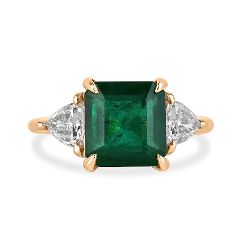 14K gold engagement ring with trillion-cut emerald and side diamonds, featuring natural Colombian emeralds and asscher accents.