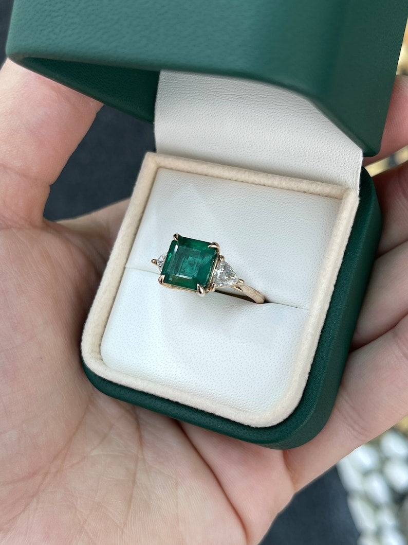 14K gold engagement ring featuring a trillion-cut emerald and diamonds, three-stone design with Colombian Emerald branding