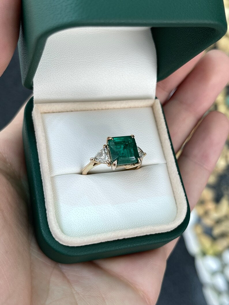 14K gold engagement ring with three stones featuring a trillion-cut emerald and diamonds, natural Colombian emerald accent.