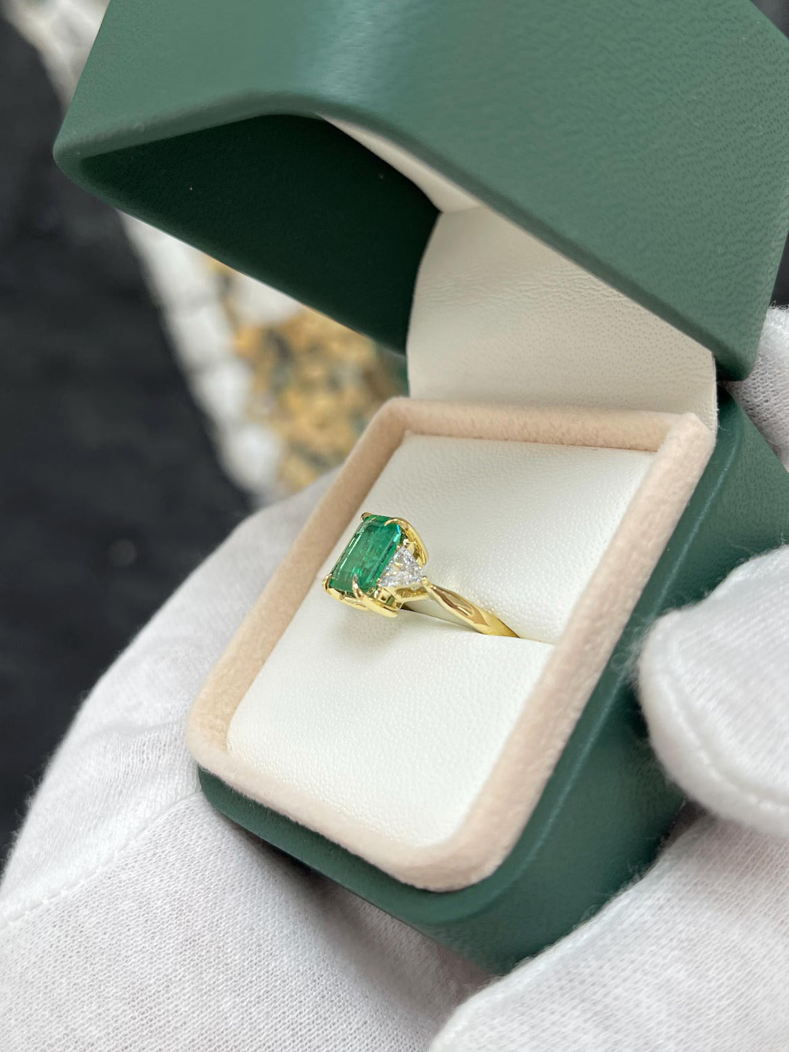 2.37 Carat Emerald Cut Emerald Features Trillion Diamond Side Stones