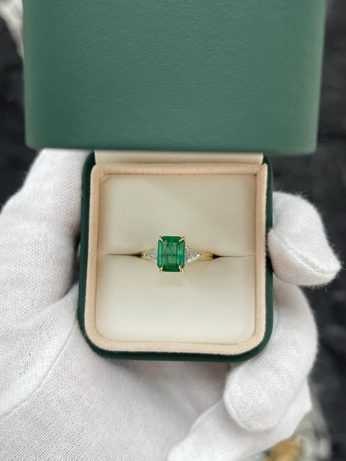 2.37 Carat Emerald Cut Emerald Features Trillion Diamond Side Stones