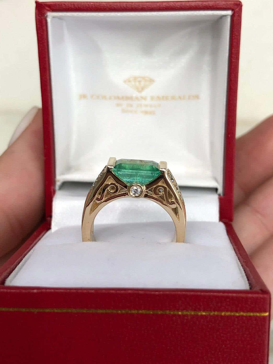Natural Colombian emerald ring with 2.60ct emerald cut three-stone design in 14K gold, featuring an east-west setting.