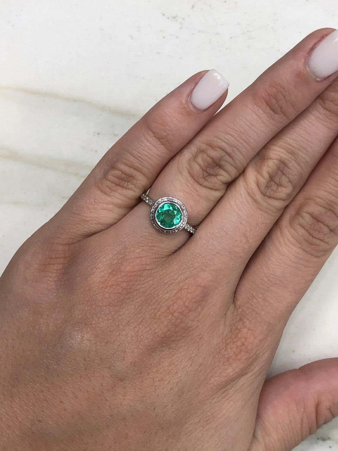 14K gold Colombian emerald diamond halo engagement ring with 1.60 carat round emerald centerpiece and surrounding diamonds.