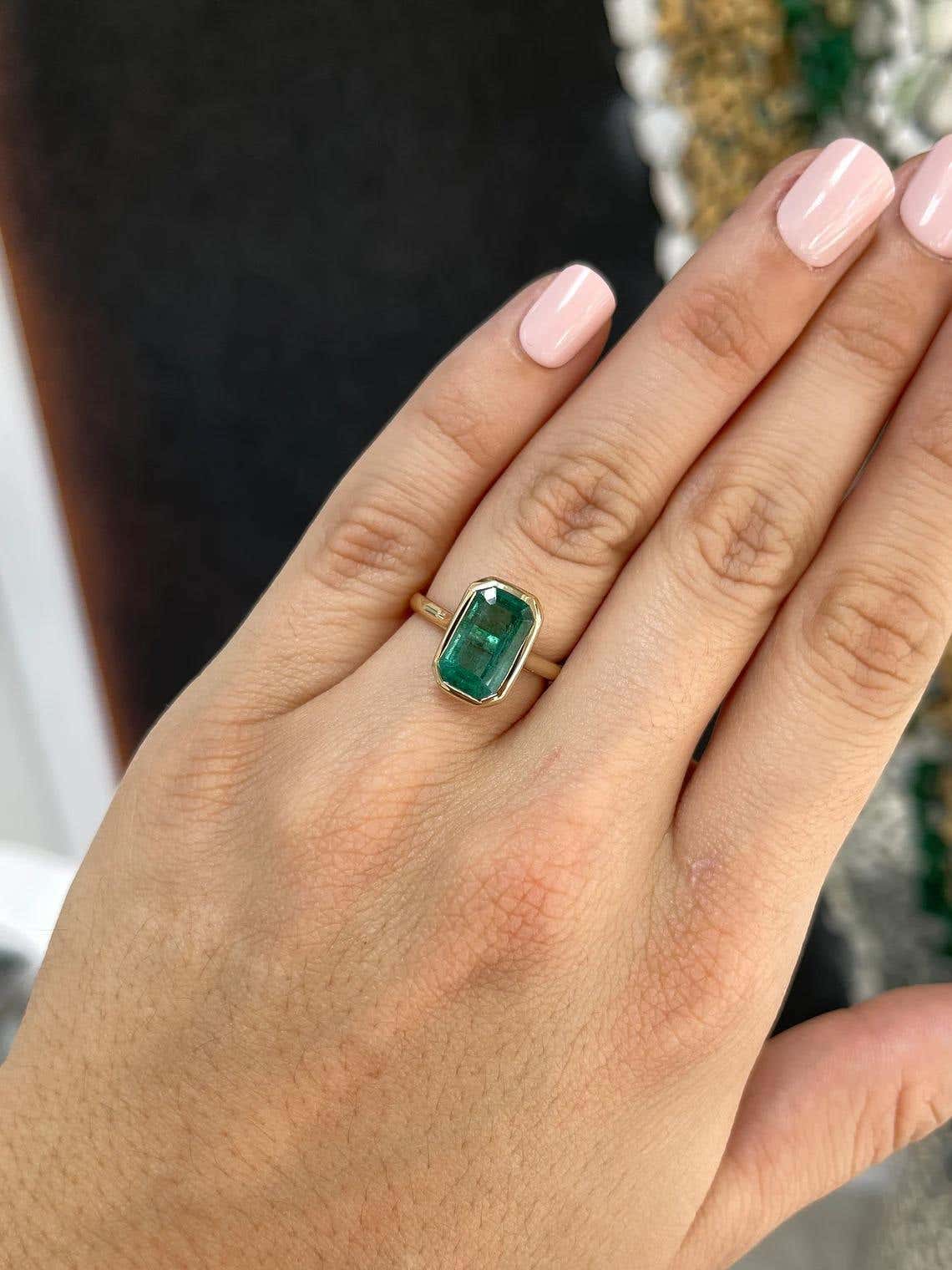 Natural emerald engagement ring with 4.76ct emerald cut bezel solitaire in blue-green, set in 14K gold by JR Colombian Emeralds.