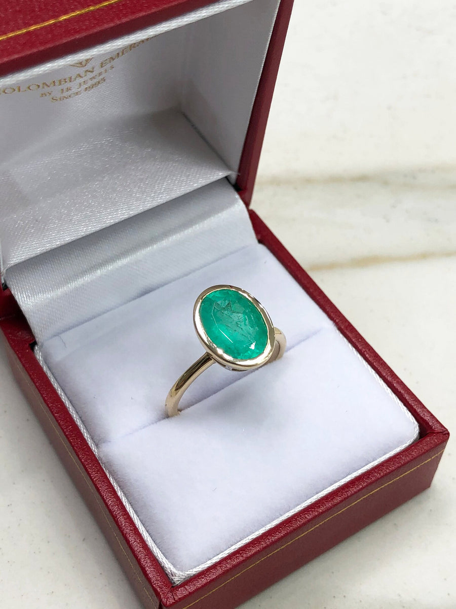 Celebrate Brilliance: 14K Gold Ring Featuring 3.0 Carat Bezel Set Oval Emerald Solitaire with Open Basket