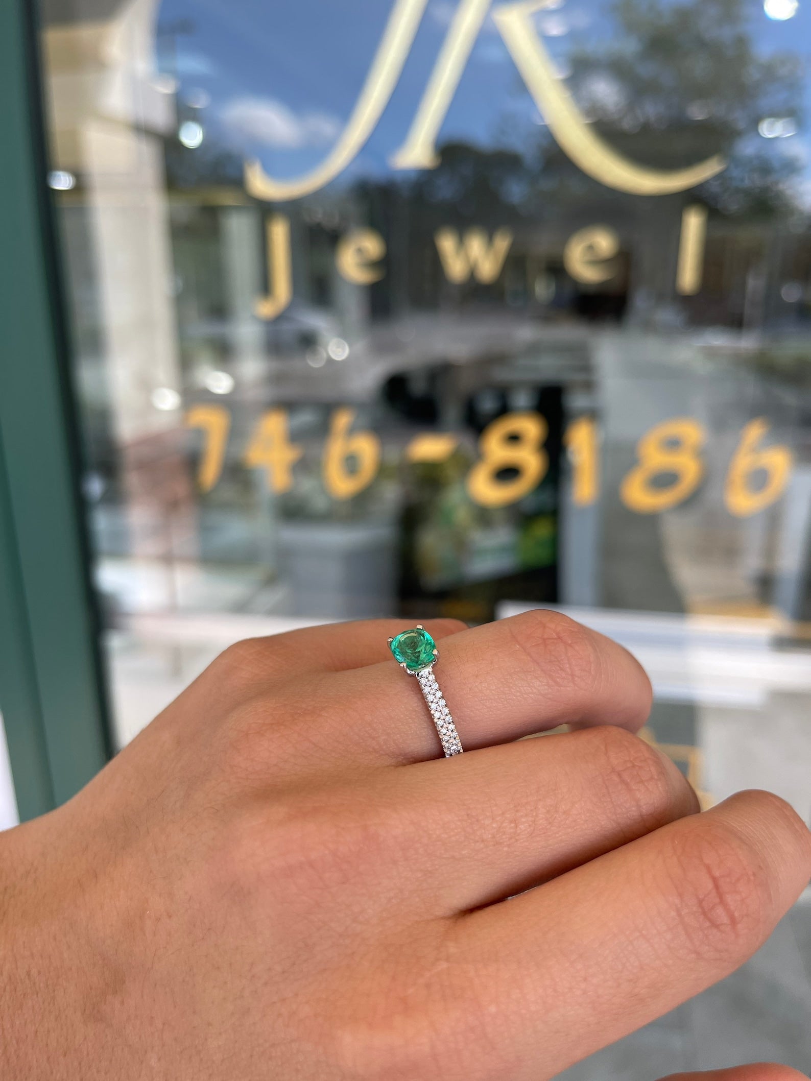 Colombian emerald cushion cut engagement ring with diamond accents in 14K gold, featuring prong setting and elegant design.